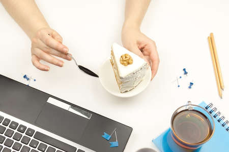 Girl  holding a piece of cake in the bowl and a teaspoon.の写真素材