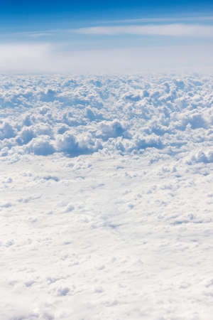 Blue clouds high above the ground, view from airplane window