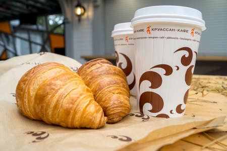 Svetlogorsk, Kaliningrad region, Russia - Oct 17, 2017: Two cups of coffee and two croissants on the street in Croissant Cafe. Inscripton on cup - Croissant Cafeのeditorial素材