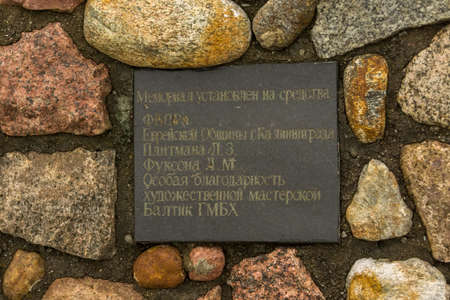 YANTARNYY, KALININGRAD OBLAST, RUSSIA - OCTOBER, 13, 2017: The memorial to the victims of the Holocaust, the sign information about at whose expense the memorial.のeditorial素材