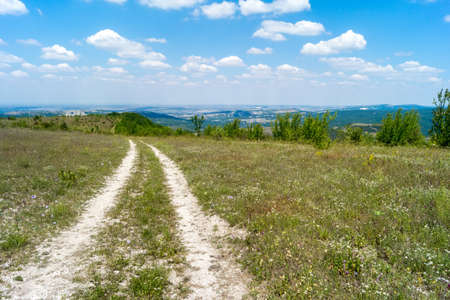 Mountain dirt road on a sunny summer dayの写真素材