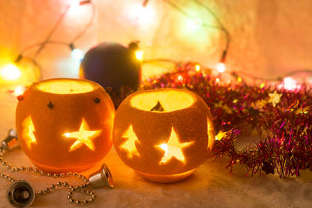 Christmas still life with orange candlesticks, tinsel and garlandの写真素材