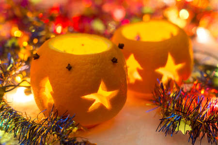 Christmas still life with orange candlesticks, tinsel and garlandの写真素材