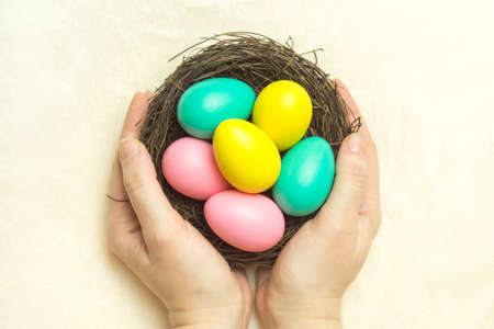 Woman holding a nest with colorful Easter eggs