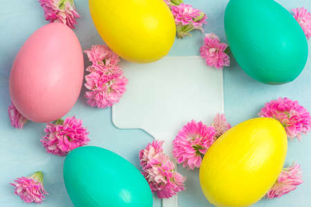 A nameplate surrounded with pink Kalanchoe flowers and colorful Easter eggs