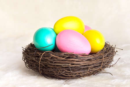 Multi-colored eggs in a nest of twigs. Easter