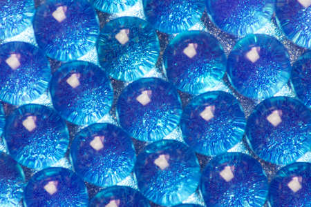 Abstract background of sparkles translucent through blue hydrogel balls