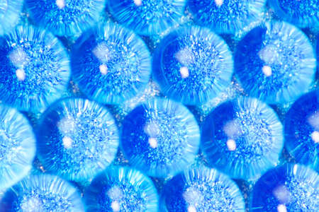 Abstract background of sparkles translucent through blue hydrogel ballsの写真素材