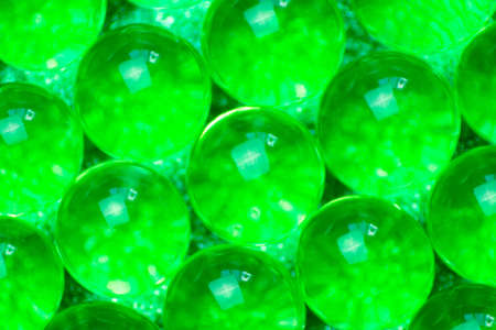 Abstract background of sparkles translucent through green hydrogel ballsの写真素材