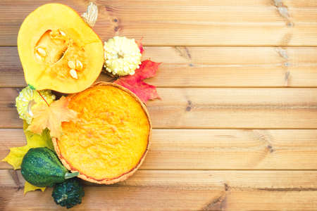 Festive wooden table with pumpkin pie and maple leaves. Happy thanksgiving dayの写真素材