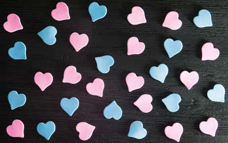 Pink and blue hearts on a black wooden surface. Valentines day and wedding backgroundの写真素材