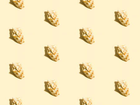 Sea shells on a beige background. A symbol of summer season relaxation - sandy beach. Seamless...
