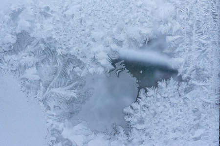 Frosty patterns on a winter window. Cold weather, Christmas mood
