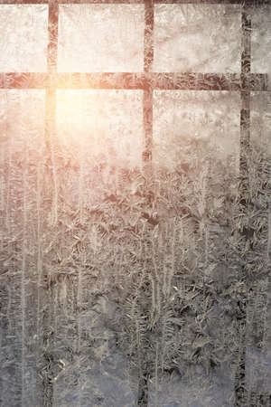 Frosty patterns on a window with a lattice on a cold winter evening. Abstract seasonal background, christmas moodの写真素材