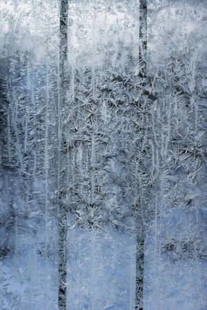 Frosty patterns on a window with a lattice on a cold winter evening. Abstract seasonal background, christmas moodの写真素材