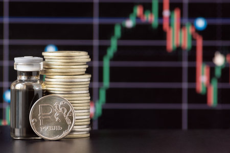 Ruble coins and a bottle of crude oil against the background of a price chart. The description on the coin - rubleの写真素材