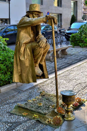 street artist in Granada painted in gold with beard and top hat and suspended in the air leaning only on a caneのeditorial素材