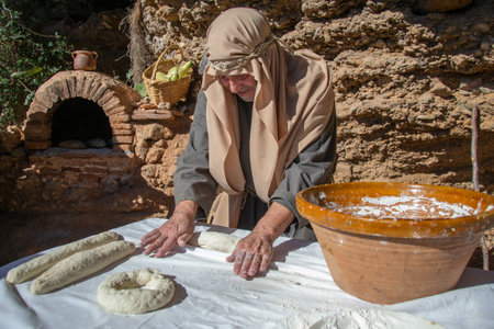 Motril, Granada, Spain, December 23, 2018: Recreation of a Christmas Nativity Scene in the annex of Motril de Tablones. Baker kneading bread next to artisan oven. Baker kneading bread next to artisan ovenのeditorial素材