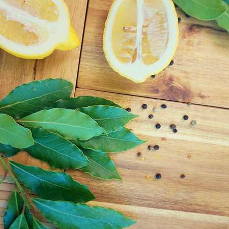  Fresh bay leaves and lemon lay on wooden cutting board.                    の写真素材