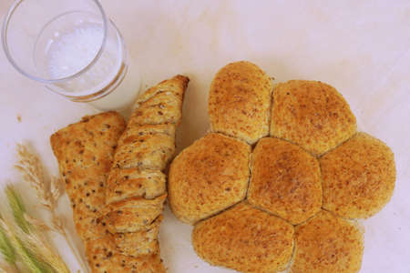 Different bread with ears and glass of milk.の写真素材