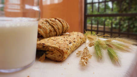Different bread with ears and glass of milk.の写真素材