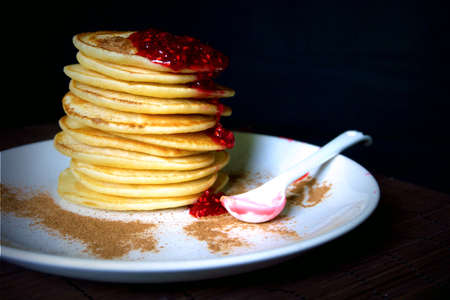 Homemade sweet pancakes with raspberries jam on a black background.の写真素材
