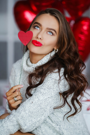 Fashion brunet girl model with red ballons.の写真素材