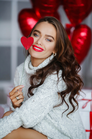 Fashion brunet girl model with red ballons.の写真素材
