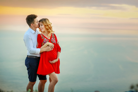 Young pregnant couple in love on summer sunny dayの写真素材