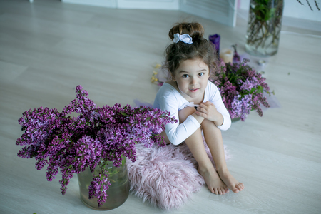 Adorable little girl dressed as a ballerina in a tutu, tying her ballet slippers.の写真素材