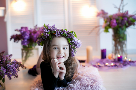 Beautiful little girl among spring flowers in blossom flowers.の写真素材