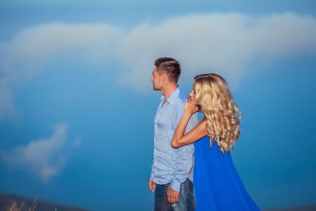 Beautiful couple of newlywed hugging at wedding day on cliff with ocean view. Stylish bride and elegant groom look at each other with love. Concept honeymoon, family, marriage, just marriedの写真素材