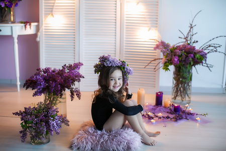 Beautiful little girl among spring flowers in blossom flowers.の写真素材