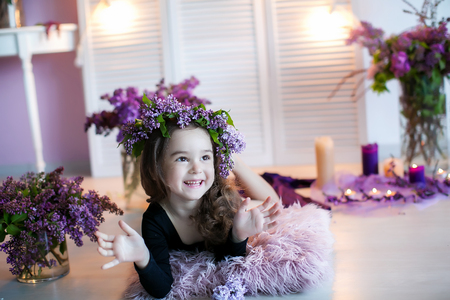 Beautiful little girl among spring flowers in blossom flowers.の写真素材