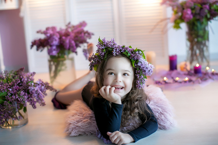 Beautiful little girl among spring flowers in blossom flowers.の写真素材