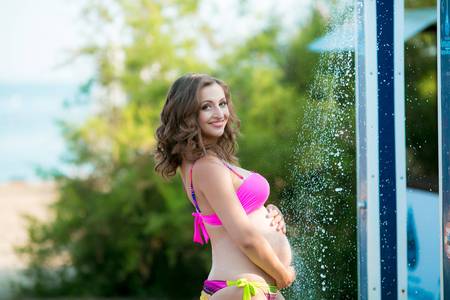 woman at sea bathed in a shower and tans in the Sunの写真素材