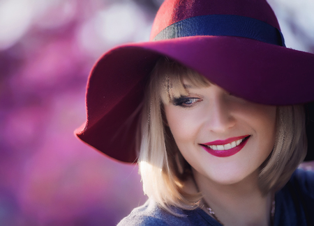Young woman smiling on the red garden background, copy spaceの写真素材