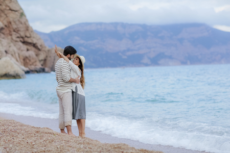 Couple of lovers on the beach. Dressed in warm spring knitted sweaters. Dinner outdoors in the open airの写真素材