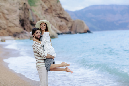 Couple of lovers on the beach. Dressed in warm spring knitted sweaters. Dinner outdoors in the open airの写真素材