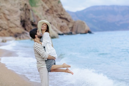 Couple of lovers on the beach. Dressed in warm spring knitted sweaters. Dinner outdoors in the open airの写真素材