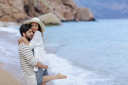 Couple of lovers on the beach. Dressed in warm spring knitted sweaters. Dinner outdoors in the open airの写真素材