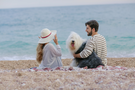 Couple of lovers on the beach. Dressed in warm spring knitted sweaters. Dinner outdoors in the open airの写真素材
