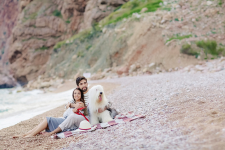 Couple of lovers on the beach. Dressed in warm spring knitted sweaters. Dinner outdoors in the open airの写真素材