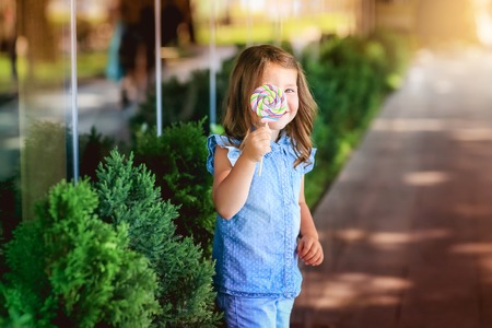 Child 5-7 years for a walk in the park with candy in his handの写真素材