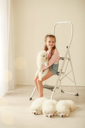 Baby Hugs the white fluffy puppy. Kids.の写真素材