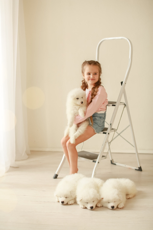 Baby Hugs the white fluffy puppy. Kids.の写真素材