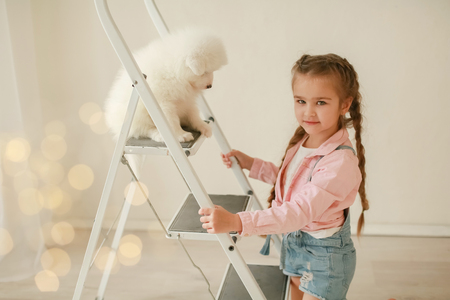 Baby Hugs the white fluffy puppy. Kids.の写真素材