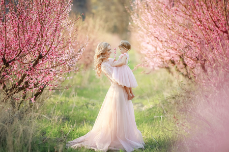 Mom with an infant in the rose garden with flowers trees.の写真素材
