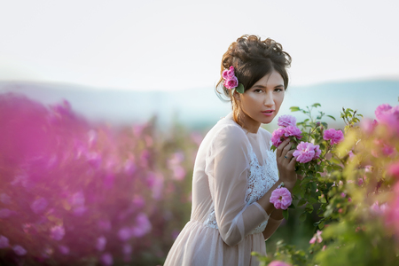 Long wedding dress, beautiful hairstyle and a field of flowersの写真素材