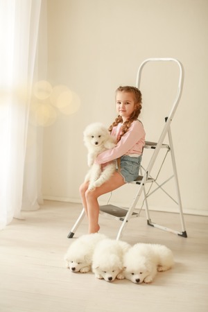 Baby Hugs the white fluffy puppy. Kids.の写真素材
